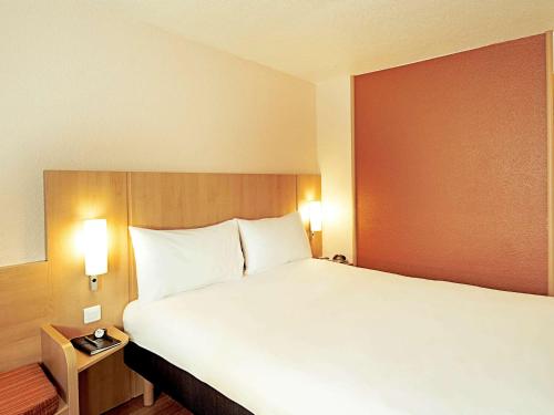 a large white bed in a hotel room at Ibis Château-Thierry in Essômes-sur-Marne