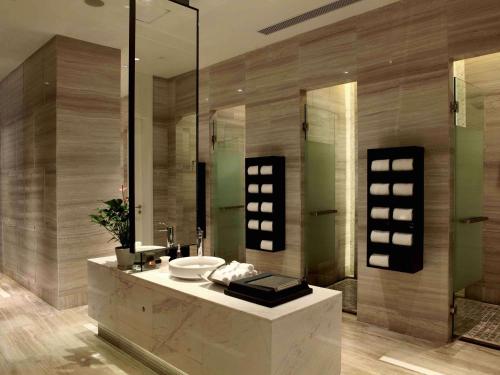 a bathroom with a sink and a mirror at Sofitel Guangzhou Sunrich - Free Shuttle Bus to Canton Fair Complex & Overseas Buyer Registration Services during Canton Fair Period in Guangzhou
