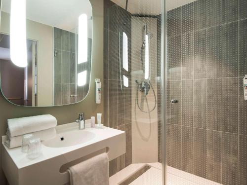 une salle de bain avec une douche, un lavabo et un miroir dans l'établissement ibis Saint Germain en Laye Centre, à Saint-Germain-en-Laye