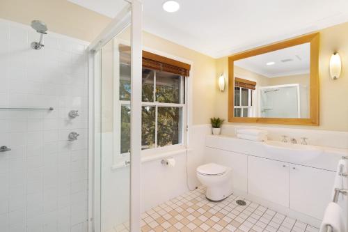 a bathroom with a toilet and a sink and a shower at Villa Cabernet in Pokolbin