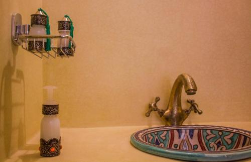 a bathroom sink with a soap dispenser next to a sink at Dar Ajgal in Dourtane