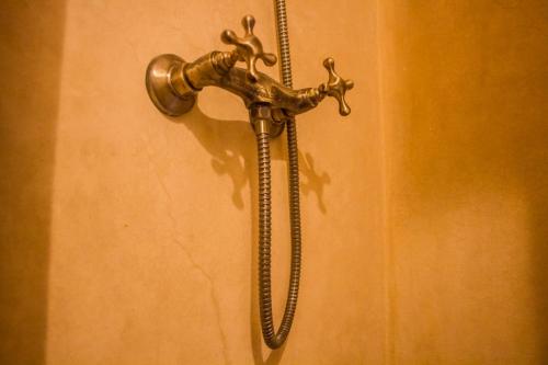 a metal shower handle hanging on a wall at Dar Ajgal in Dourtane