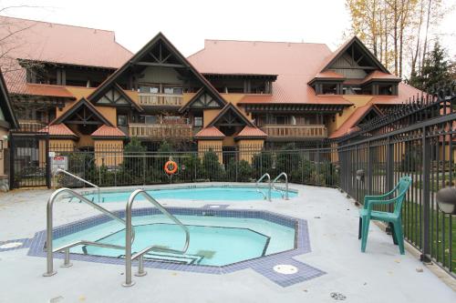 a swimming pool in front of a large house at Sunpath Condos by Whistler Retreats in Whistler