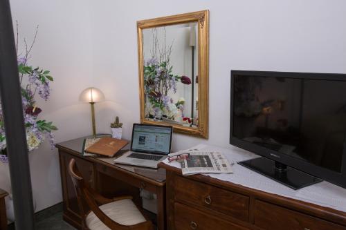 a desk with a laptop computer and a television at Hotel Villa San Lucchese in Poggibonsi