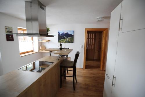 a kitchen with a counter and a table with chairs at Bergbauernhof Pabulariu in Boden