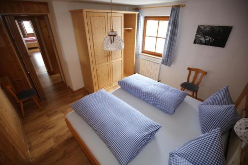 a bedroom with a bed with two blue pillows at Bergbauernhof Pabulariu in Boden