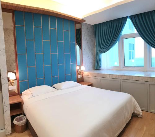 a bedroom with a large bed and a blue wall at LUXURIOUS EXQUISITE SEAVIEW PRIVATE MARINA CONDOMINIUM in Nusajaya