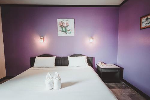 um quarto com uma cama com sapatos brancos em AVA Hotel em Phitsanulok