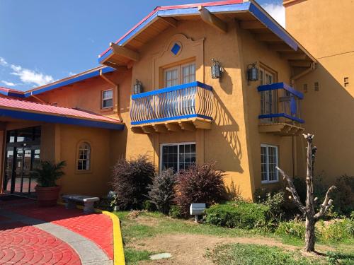 a yellow building with a balcony on the side of it at Americas Best Value Inn Denver in Denver