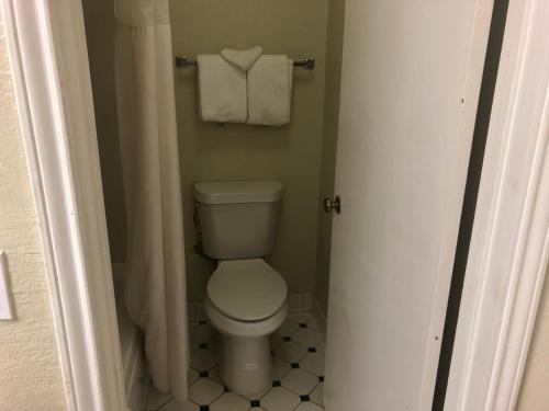 a bathroom with a toilet and towels on a wall at Americas Best Value Inn Denver in Denver
