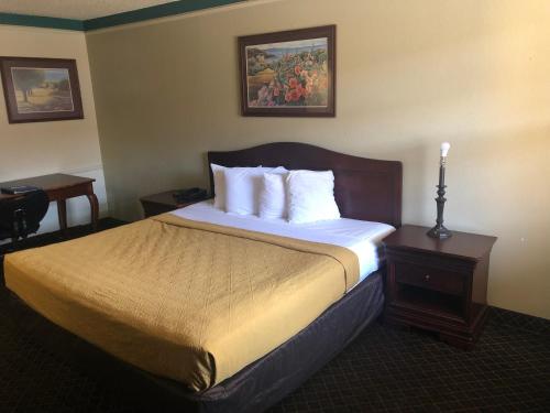 a hotel room with a large bed with white pillows at Americas Best Value Inn Denver in Denver