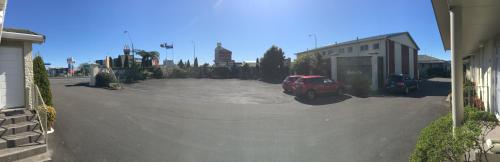 a parking lot with a red car parked in it at Amber Court Motel in New Plymouth