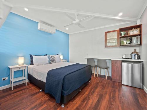 1 dormitorio con cama y pared azul en Almare Tourist Motel, en Ballina