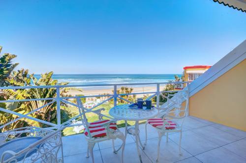 a balcony with a table and chairs and the beach at Haus am Strand - on the Beach in Wilderness