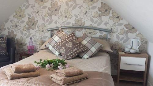 a bedroom with a bed with a bunch of pillows at Carvetii - Gemini House - 4 bed House sleeps up to 8 people in Tillicoultry