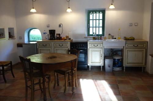 L'Hermitage في Yenne: مطبخ مع طاولة وكراسي ومغسلة