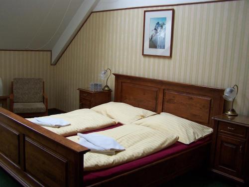 een slaapkamer met een bed en een stoel bij Hotel Paříž in Jičín