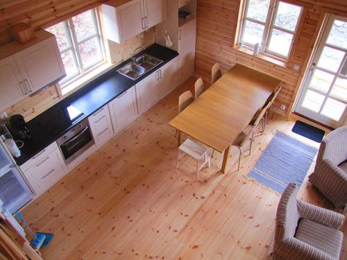 an overhead view of a kitchen with a wooden table and chairs at Linnaeus - 6 person cabin in Ål