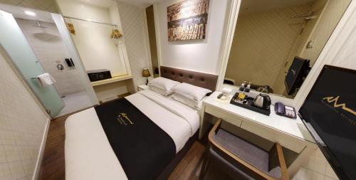 a hotel room with a bed and a sink and a mirror at Manhattan Business Hotel Damansara Perdana in Petaling Jaya