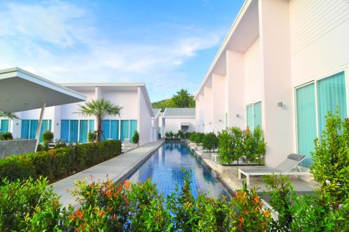 an exterior view of a villa with a swimming pool at The Palmery Resort in Kata Beach