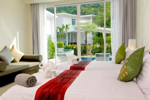 um quarto com uma cama grande e uma janela grande em The Palmery Resort em Kata Beach