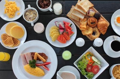 a table full of plates of food with different foods at The Palmery Resort in Kata Beach