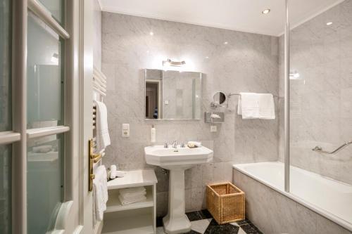 a bathroom with a sink and a shower and a tub and a sink at TAUROA Landhaus zu Appesbach in St. Wolfgang
