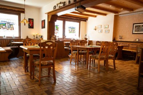 a restaurant with wooden tables and chairs in a room at Kühn's Gästehaus in Pünderich