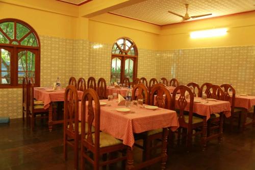 ein Restaurant mit Tischen und Stühlen in einem Zimmer in der Unterkunft Lake Palace Family Resort Kumarakom in Kumarakom