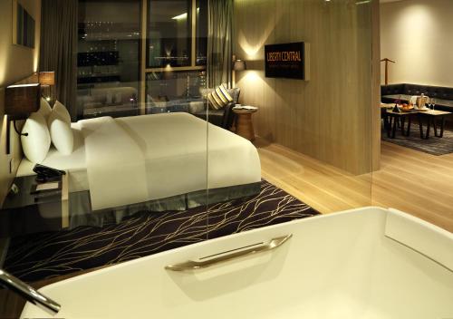 a hotel room with a bed and a table at Liberty Central Saigon Citypoint in Ho Chi Minh City