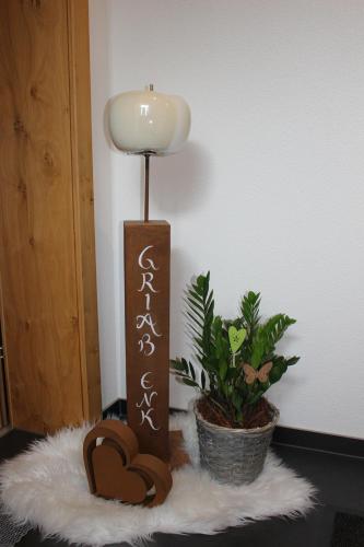 a candle on a table with a lamp and a plant at Alpenapart Hochzeiger in Jerzens