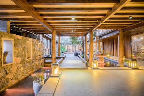 a lobby of a building with a stone wall at 丽江束河元年别院 Yuannian Lijiang in Lijiang