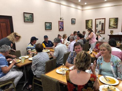 um grupo de pessoas sentadas em mesas em um restaurante em Pingelly Hotel em Pingelly