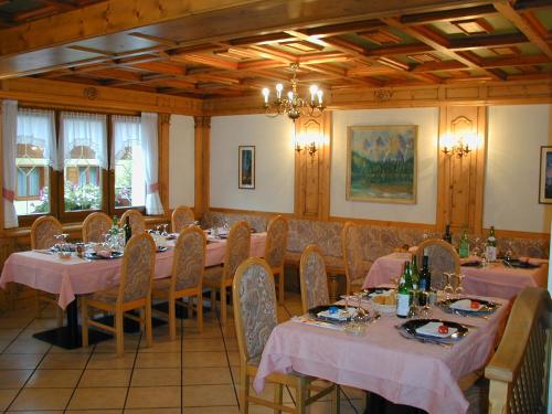 a dining room with tables and chairs with pink table cloth at Alpen Hotel Vidi in Madonna di Campiglio