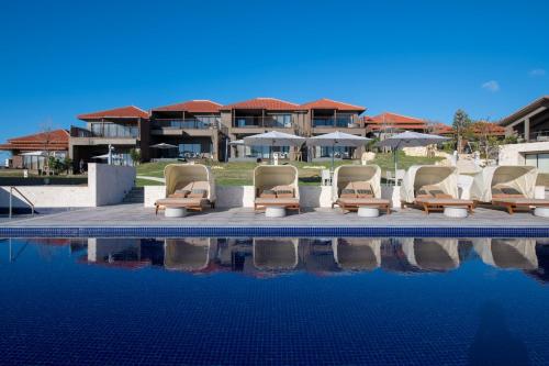 a group of chairs sitting next to a swimming pool at THE HIRAMATSU HOTELS & RESORTS GINOZA OKINAWA in Ginoza