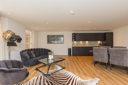 a living room with a table and chairs and a kitchen at Lage Wurft Beach Apartments in Noordwijk