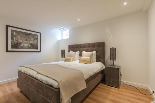 um quarto com uma cama grande e uma cabeceira castanha em Lage Wurft Beach Apartments em Noordwijk