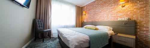 a hotel room with a bed and a brick wall at Lunevo na Volge in Lunevo