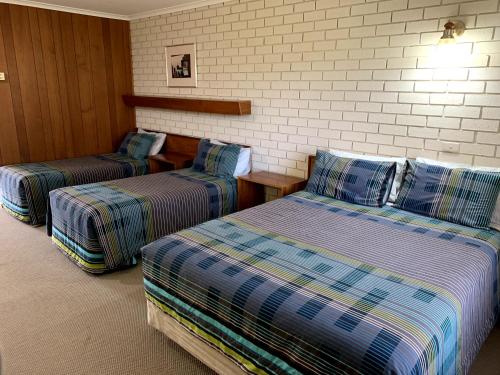 a room with three beds in a room at Kingswood Motel in Tocumwal