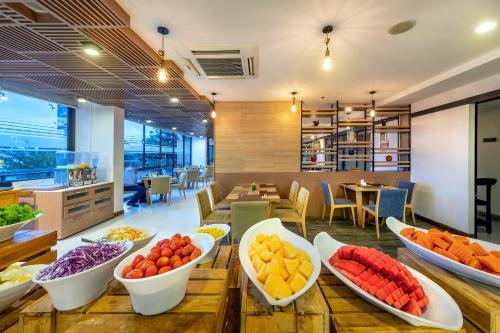 a buffet with bowls of fruits and vegetables on a table at PLAAI Prime Hotel Rayong SHA Extra Plus in Rayong