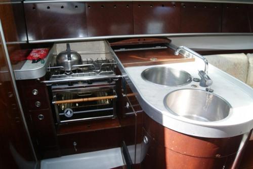 uma pequena cozinha com um lavatório e um fogão em Inolvidable experiencia en un velero de 11 metros! em Zumaia