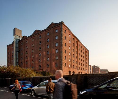 Un uomo che cammina per una strada di fronte a un edificio di Native Manchester a Manchester