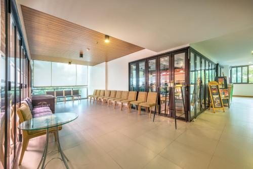 a large room with chairs and tables and windows at PLAAI Prime Hotel Rayong SHA Extra Plus in Rayong
