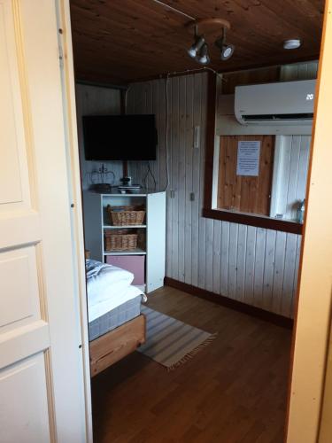 a small room with a bed and a television at Örnatorpet Ullared in Ullared