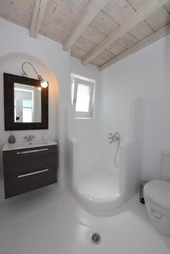 a white bathroom with a toilet and a sink at Villa Pearl near Ornos by Diles Villas in Agios Ioannis Mykonos