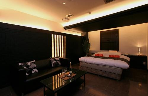 a living room with a couch and a bed at HOTEL BANJAR in Tokorozawa