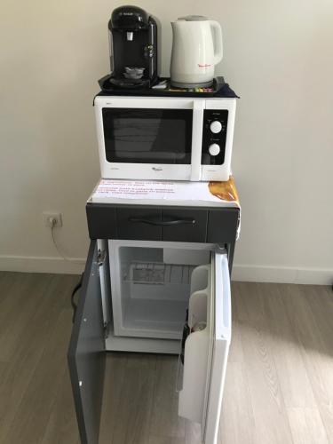 Eine Mikrowelle steht auf einer Arbeitsplatte. in der Unterkunft maisonnette indépendante in Chartres