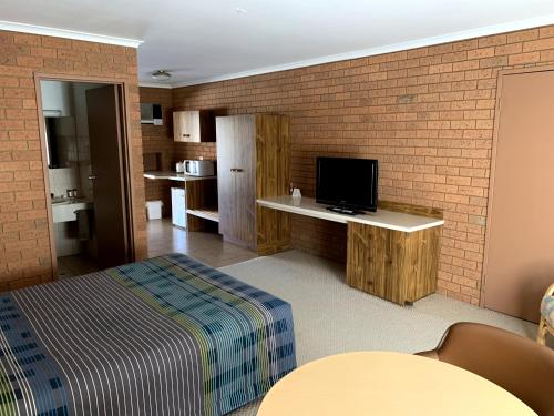 a hotel room with a tv and a bed at Kingswood Motel in Tocumwal