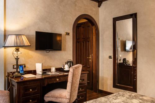 a room with a bed, chair, desk and a lamp at Grand Hotel Baglioni in Florence