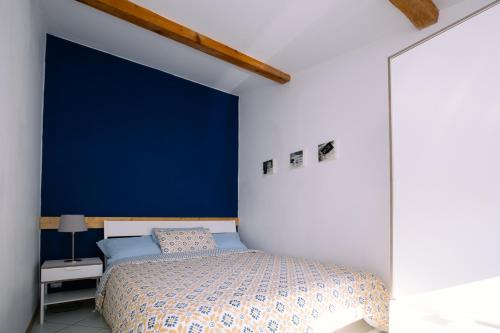 - une chambre avec un mur bleu et un lit dans l'établissement 2 pièces avec grande terrasse - Centre de Toulon, à Toulon
